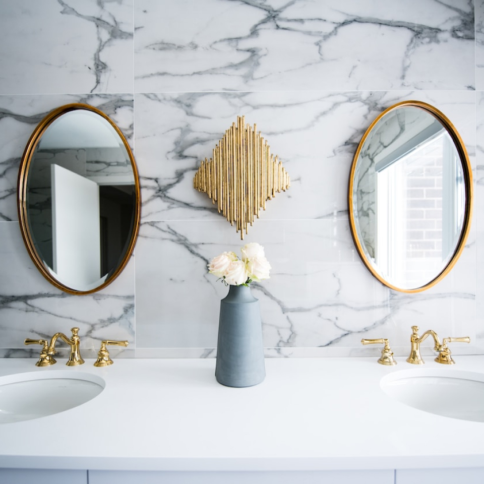 Luksuriøst baderom med marmorvegger, speil og gylne kraner designet av rørlegger og VVS-eksperter i Oslo